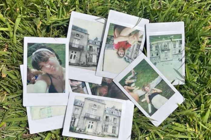 A collection of Polaroids depicting teenagers and a house's exterior, scattered over a grassy lawn.