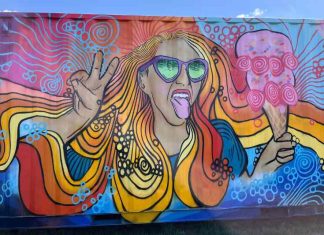A brightly colored mural of a woman with flowing blonde hair enjoying an ice cream cone.