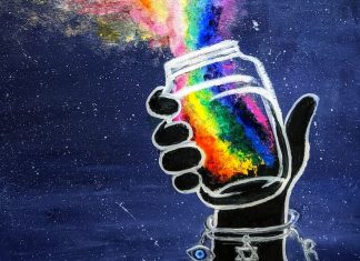 A hand holding a jar releasing a rainbow