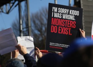 A hand holds up a sign that reads, "I'm sorry kiddo, I was wrong. Monsters do exist."