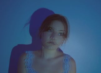 A blurry, blue-tinted photo of a girl who is looking off to the side.