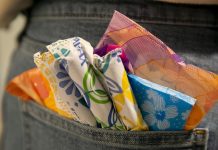 Tampons and pads sticking out of the back pocket of a pair of jeans.