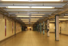 A slightly blurry scene of a well-lit, beige walled, underground station.