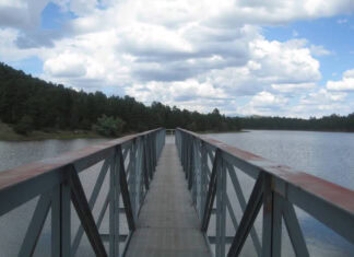 Connection A long pier stretches out into a gray-blue lake. It doesn't quite reach the opposite shore.
