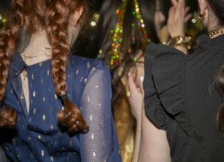 Two young girls, all dressed up, dance at a bat mitzvah.