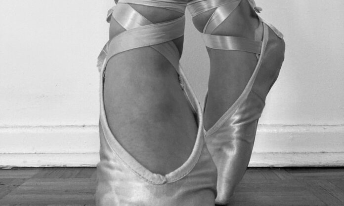 A ballerina's pointed feet are shown in a black and white image.