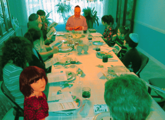 Preserving My Grandfather’s Passover Legacy The author looks up from the table while her grandfather leads his last seder before his death in 2017.