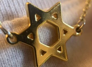 Two Battles, One Identity: Jewish Women Confronting Sexism and Antisemitism A gold Jewish star hangs on a necklace chain over a white shirt.